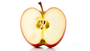 Close-up of fresh honeycrisp apple cut in half showing crisp, juicy interior flesh with water droplets and natural light reflection, isolated on white background